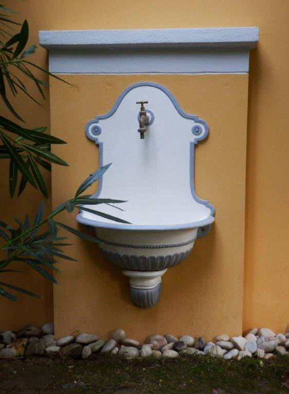 Waschbecken im Garten des venezianischen Gutshauses Montebello in Antipernoi auf Korfu an gelber Natursteinmauer